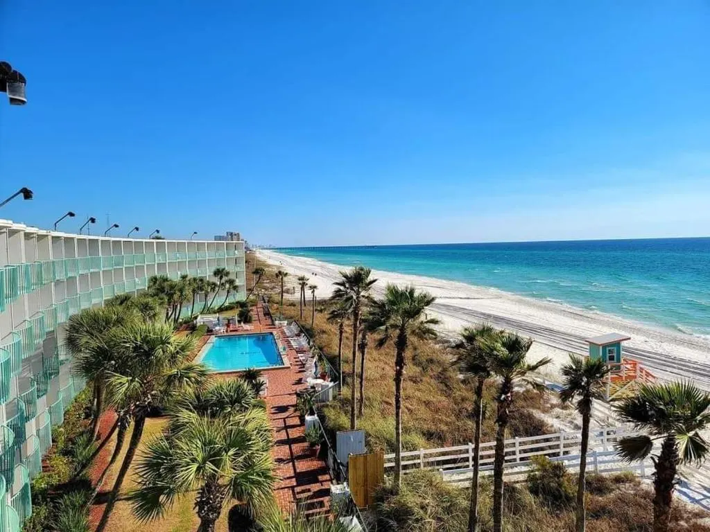 Aerial view of the balconies overlooking the garden, terrace, outdoor pool, beach, and sea, at Casa Loma Panama City Beach