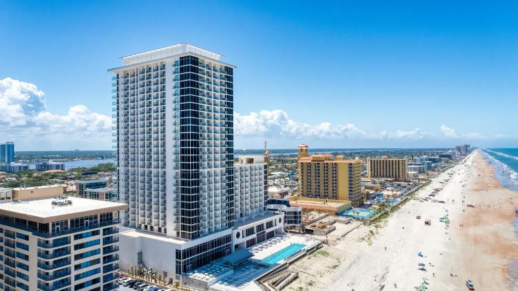 Aerial view of the hotel, outdoor pool, and beach by Daytona Grande Oceanfront Resort
