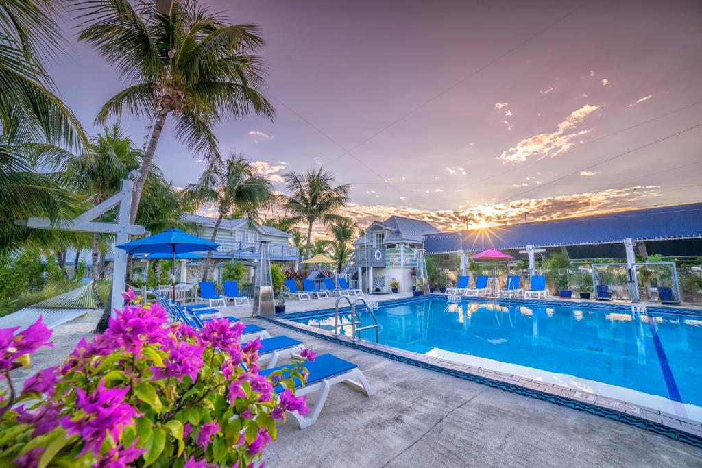 Outdoor pool surrounded by trees and chairs at sunset at Ibis Bay Resort Key West