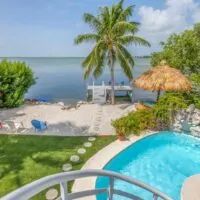 View from the terrace at Oceanfront Villa, of the outdoor pool, private beach, and ocean, in Key West