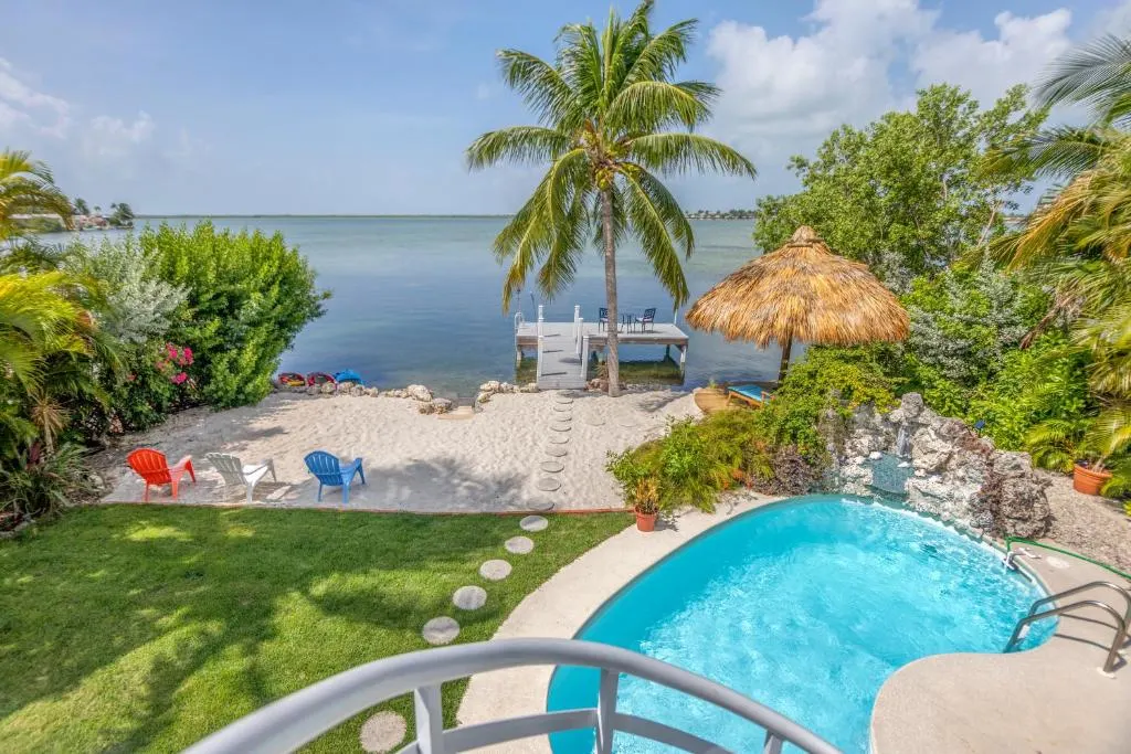 View from the terrace at Oceanfront Villa, of the outdoor pool, private beach, and ocean, in Key West